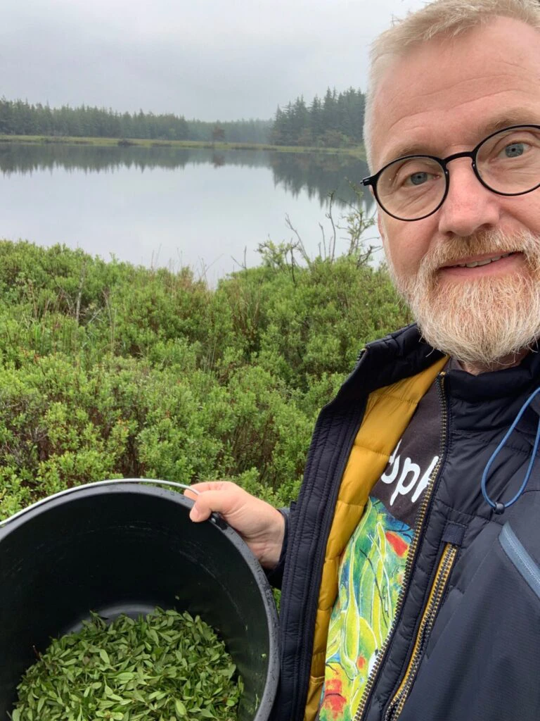 Mand står med spand af indsamlet Porse